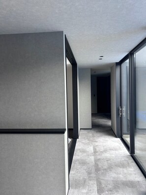 Un couloir moderne doté de grandes portes vitrées et d’un design minimaliste.