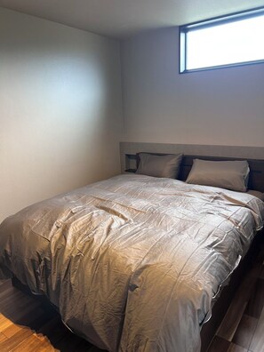 Une chambre à coucher avec un lit, une fenêtre et un plancher en bois.