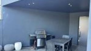 A room with a dining table and chairs, a small kitchen area, and a door leading to another space. - Queen + 2 Double Beds + 2 Futons (ichinomiyamachiitinomiya)