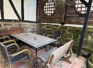 A rustic outdoor seating area with a tiled table, wicker chairs, and a bench. - Grebenstein with castle & towers near Sleeping Beauty's Sababurg & Rapunzel's Trendelburg (Grebenstein)