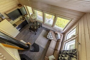 A compact living space with a dining area, sofa, and a kitchen.
