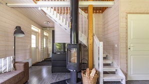 Un intérieur moderne avec un poêle à bois, un escalier et un canapé.