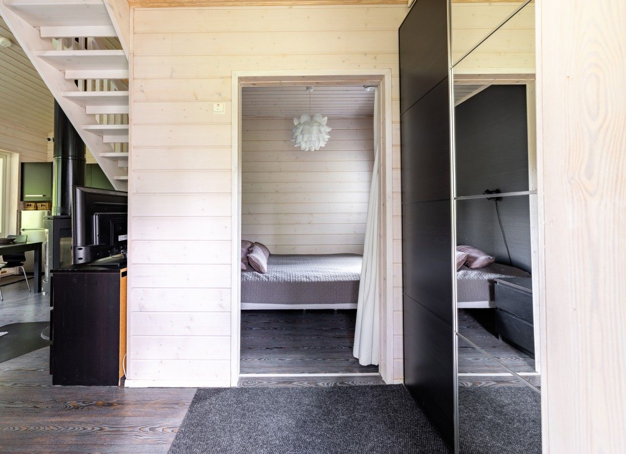 A room with a bed, a small table, and a staircase.