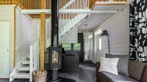 Un salon chaleureux avec une cheminée, un canapé et un escalier.