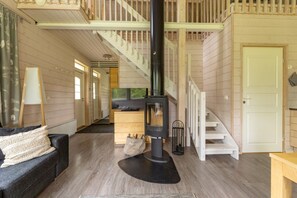 Un intérieur chaleureux avec une cheminée, un escalier en bois et un canapé.