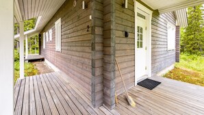 Une maison en bois avec un porche, une porte et une fenêtre.