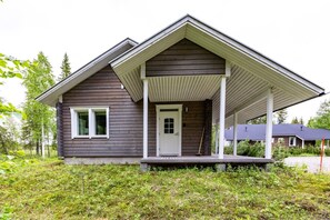Ett envåningshus med en veranda framför, en dörr och ett fönster.