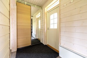 Ein Korridor mit Holzwänden, einem schwarzen Teppich und einer Tür mit Fenster.