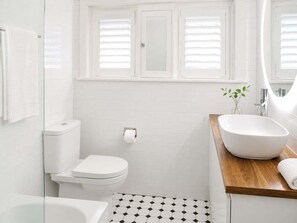 Ein Badezimmer mit Toilette, Bidet und Waschbecken mit großer Schüssel.