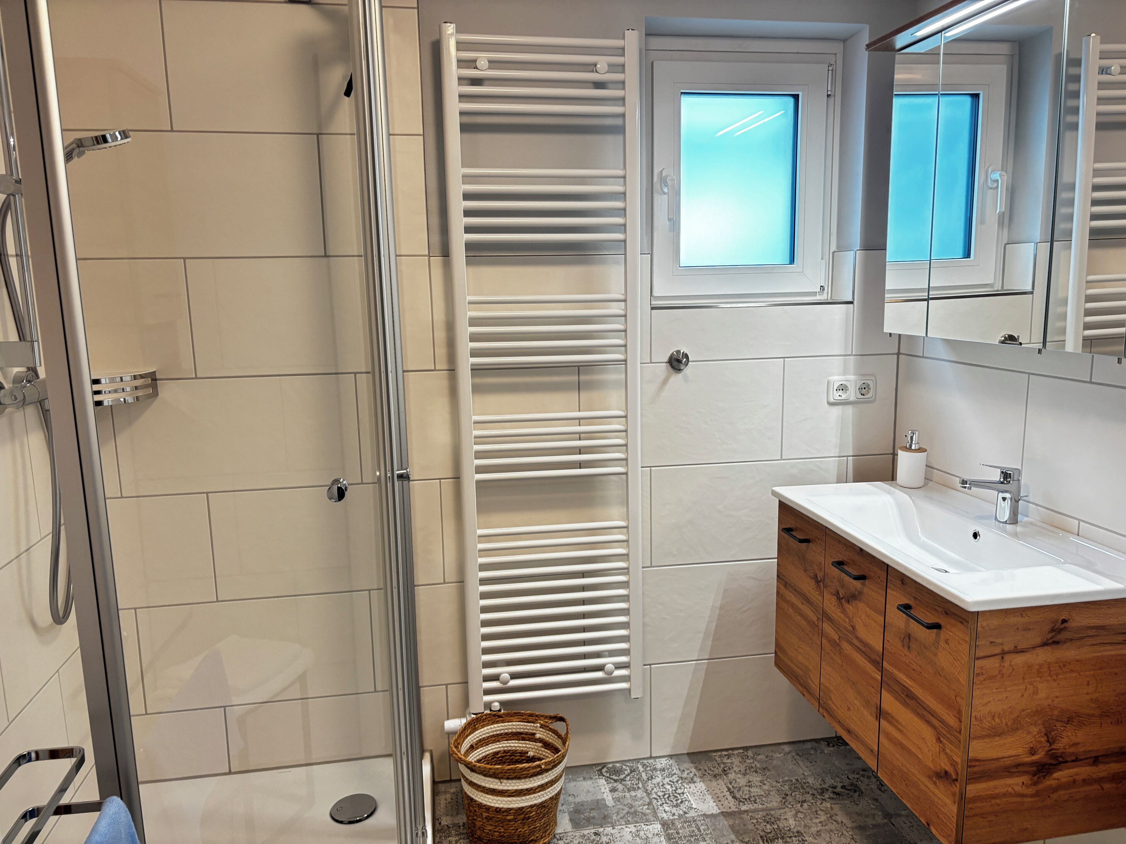 Ein Badezimmer mit Dusche, Toilette, Waschbecken und Spiegel.