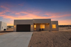 A modern two-story house with a garage, a covered entryway, and a driveway.