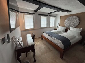 A bedroom with a bed, bedside tables, a desk, and a large wall decoration. - Grebenstein with castle & towers near Sleeping Beauty's Sababurg & Rapunzel's Trendelburg (Grebenstein)