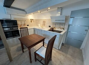 A modern kitchen with a dining table, chairs, an oven, a sink, and a refrigerator. - Grebenstein with castle & towers near Sleeping Beauty's Sababurg & Rapunzel's Trendelburg (Grebenstein)
