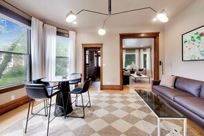 Ein modernes Wohnzimmer mit Essbereich, großen Fenstern und einer Karte an der Wand.