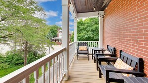 Une terrasse extérieure couverte, dotée de bancs en bois et d’un mur en briques.