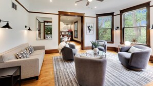 Un salon moderne avec un canapé, des fauteuils, une table basse et un ventilateur de plafond.