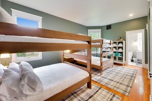 A bunk bed room with a window, a wardrobe, and a bathroom. - The Reunion House: Two Massive Units in One! (Michigan City)