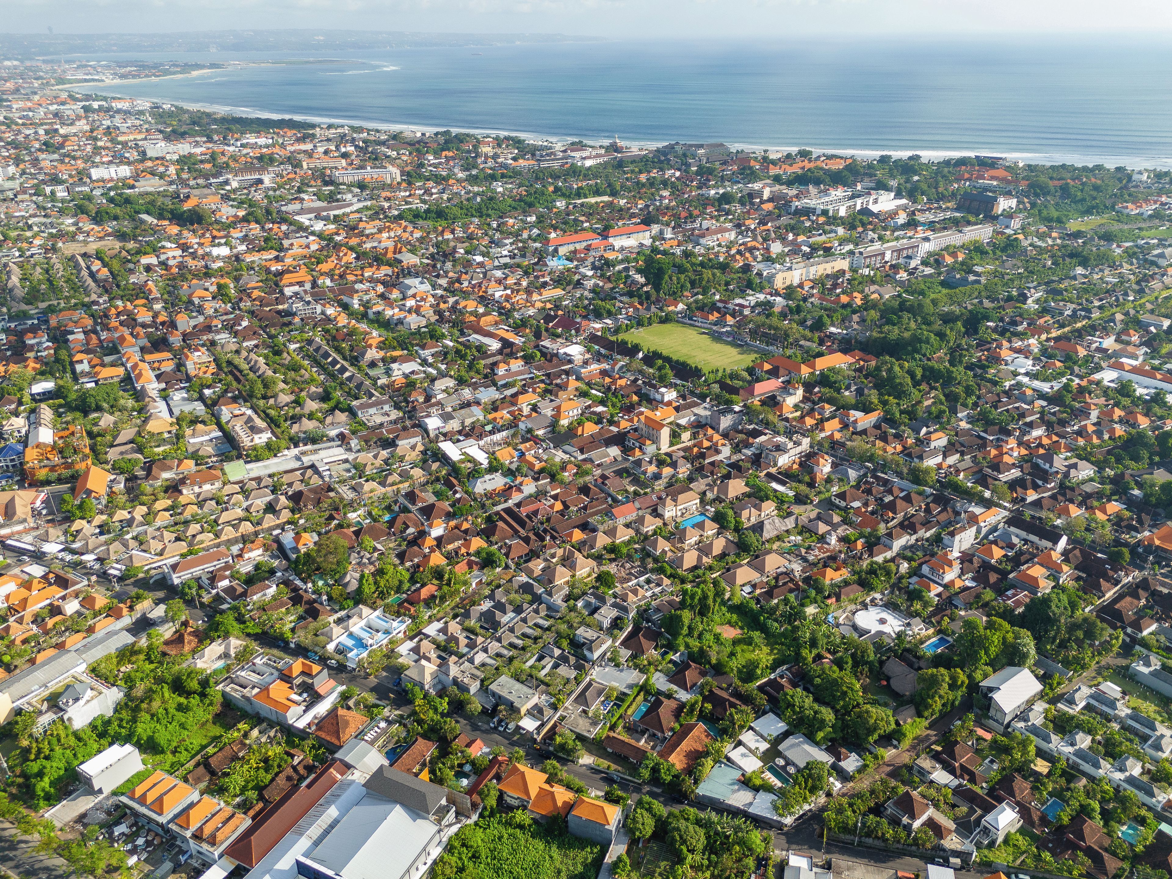Un quartier résidentiel densément peuplé, caractérisé par une grande variété de styles architecturaux et un vaste espace vert en son centre.