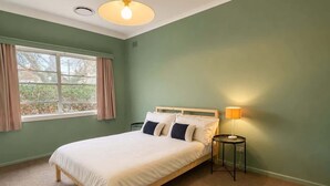 A bedroom with a bed, a window, a lamp, and a ceiling light. - Nandi - Vintage Character (Orange)