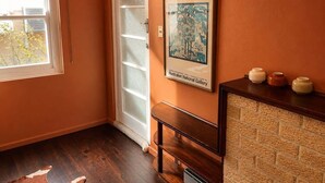 A room with a wooden bench, a framed picture, a door with frosted glass, and a window with blinds. - Nandi - Vintage Character (Orange)