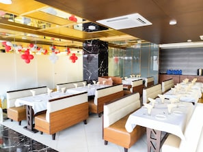 En restaurant med båse og borde, marmorgulv og moderne loftdesign.