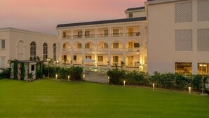 A multi-story hotel with a courtyard, balconies, and a well-lit entrance. - Rudra Imperial Resort (Sitapur)