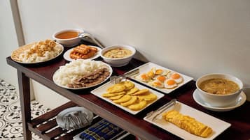 Una mesa de comedor con diversos platos que incluyen arroz, carne, huevos y sopa.