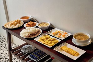 A dining table with various dishes including rice, meat, eggs, and soup.