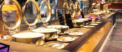 A buffet setup with multiple serving stations, each with a round serving tray and a metal bowl.