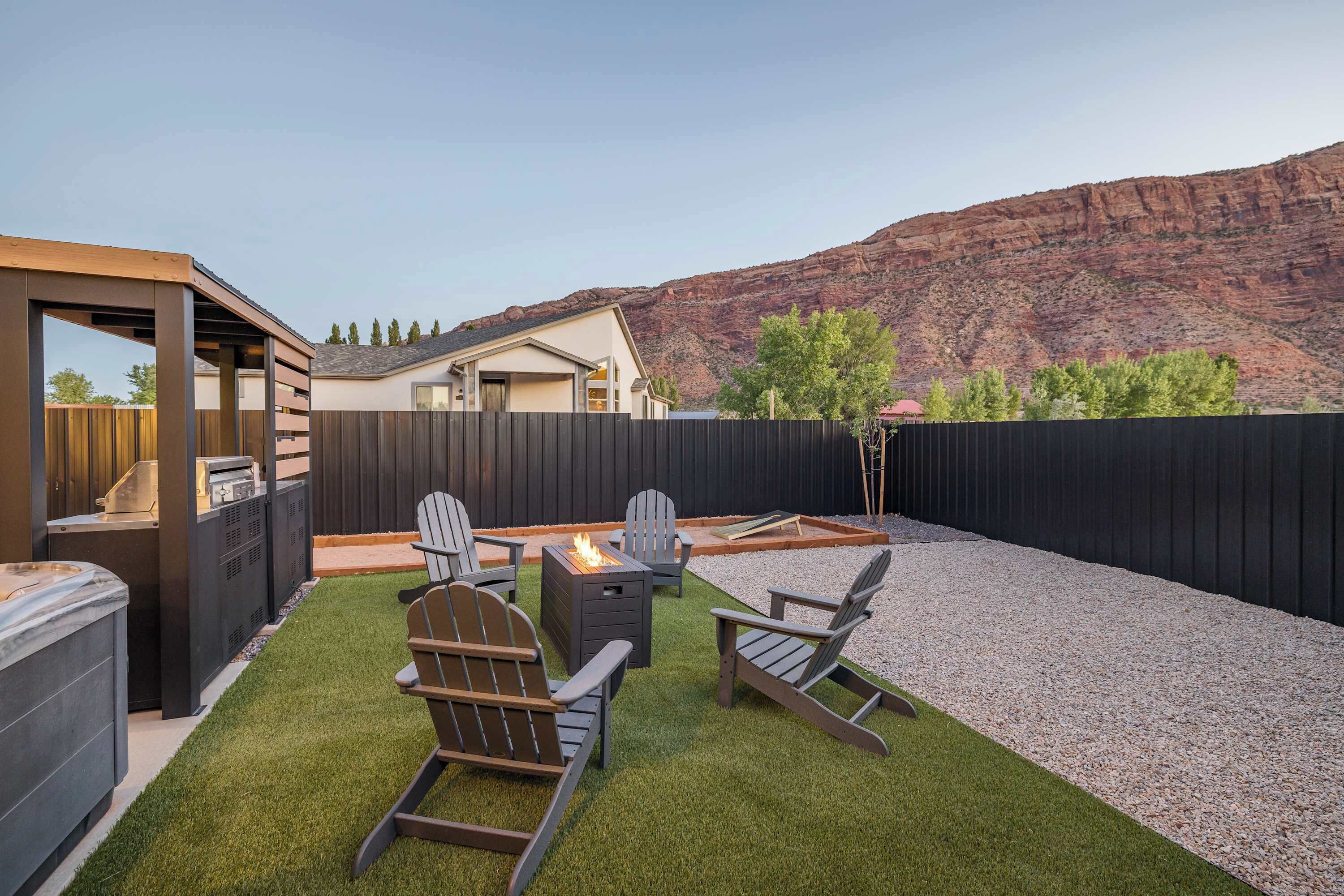Un jardin avec un espace barbecue, des sièges d’extérieur et une vue sur une montagne.