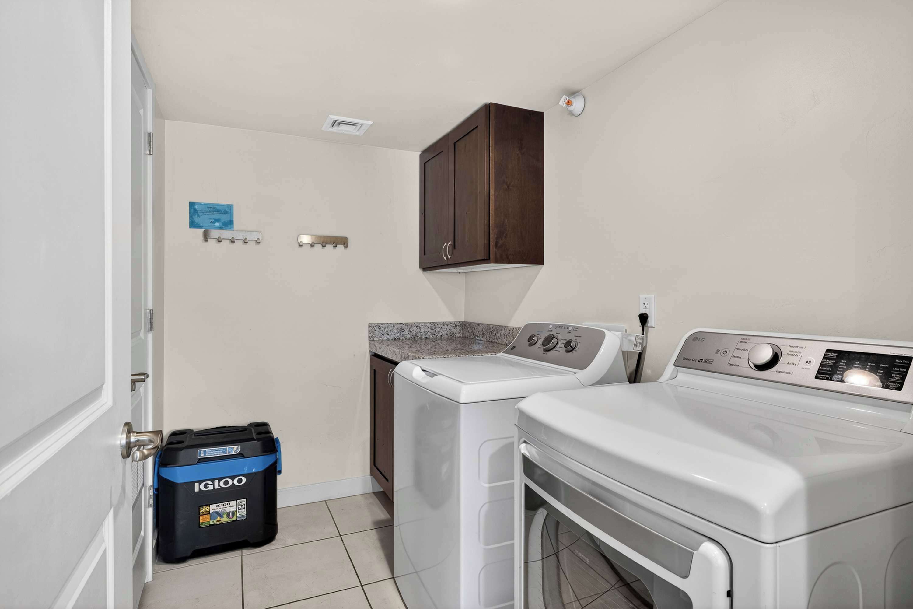 A laundry area with a washing machine, dryer, and a storage unit.