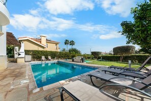 A swimming pool with lounge chairs, a building with a tiled roof, and a well-maintained garden. - Villa Latchi Marina 3 -  a villa that sleeps 6 guests  in 3 bedrooms (Latchi)