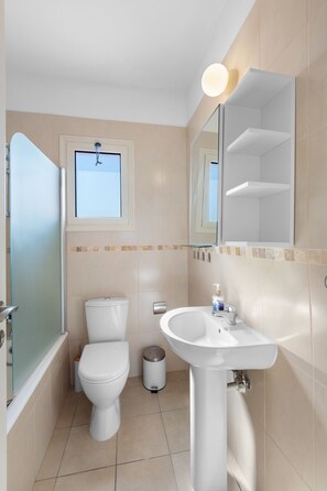 A bathroom with a toilet, sink, and mirror. - Villa Latchi Marina 3 -  a villa that sleeps 6 guests  in 3 bedrooms (Latchi)