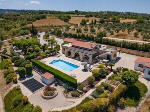 A villa with a swimming pool, outdoor seating, and a landscaped garden.