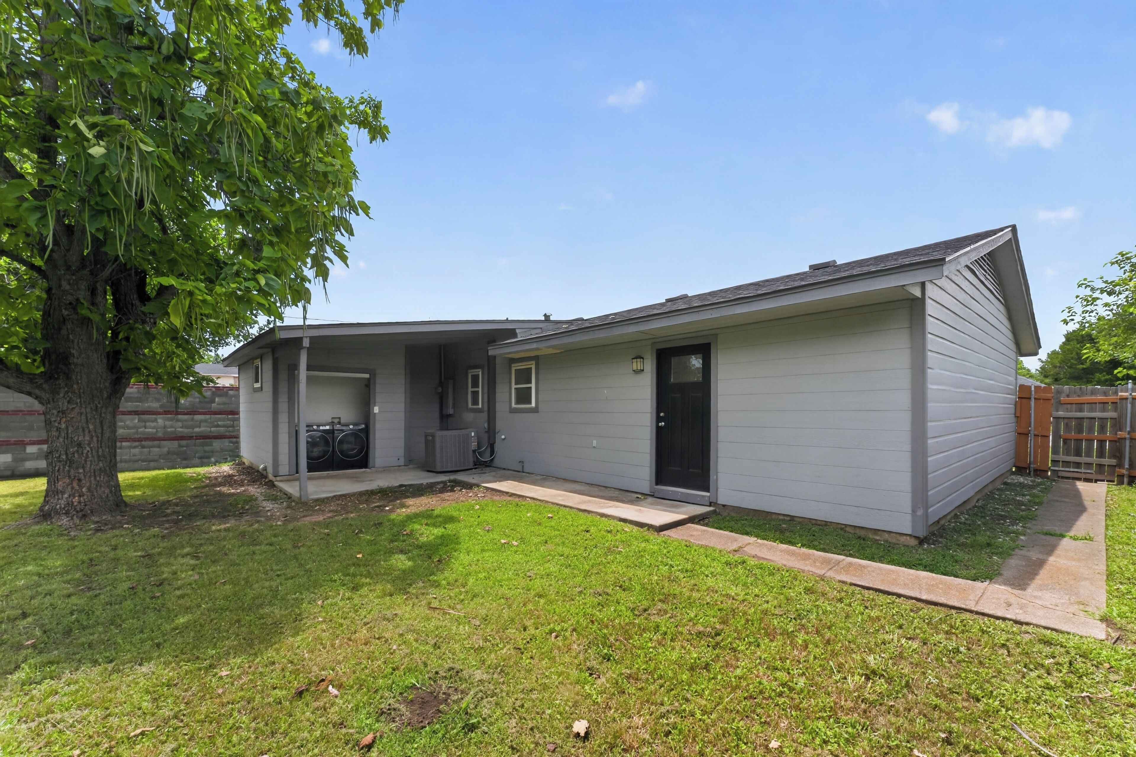 A single-story house with a covered porch, a garage, and a small front yard.