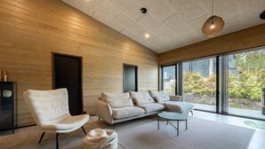 Un intérieur moderne avec un mur en bois, un canapé, un fauteuil et une table ronde.