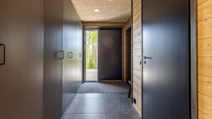 Un couloir donnant sur l’extérieur, une porte sur la droite et un plafond à motifs.
