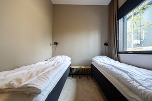 A small room with two single beds, a small table, and a window with a view of the outside. - Villa Noel A | Premium 4BR Villa | Near Ski Lifts (Kittilä)