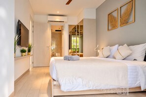 A modern bedroom with a large bed, a flat-screen TV, and a view of the outdoors. - Modern 2-Bedroom Apartment at Cassia Phuket (Choeng Thale)