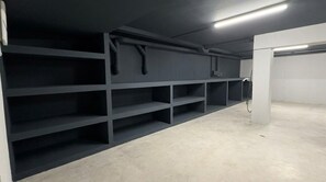 Ett rent, tomt rum med grå hyllsystem och ett betonggolv.