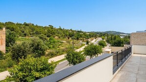 A balcony with a view of a road, greenery, and distant hills. - Villa Las Golondrinas New 100% July 2026  20 minutes walk from Sitges Beaches (Sitges)
