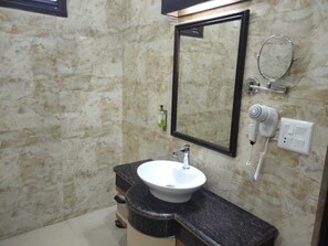 Luxe tweepersoonskamer | Badkamer | Een aparte badkuip en douche, een haardroger, handdoeken, zeep