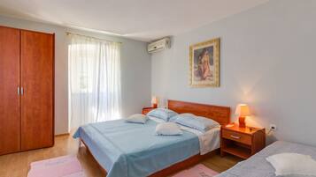 A bedroom with a bed, bedside tables, a wardrobe, and a painting on the wall.
