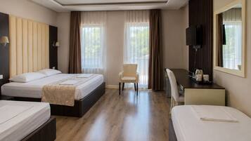 A hotel room with two beds, a desk, a chair, and a TV.