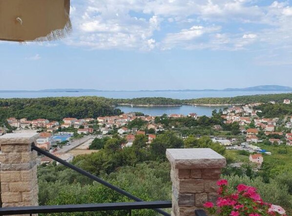 A coastal town with a view of the sea, houses, and greenery. - Andrija Sea View Apartments (Rab)