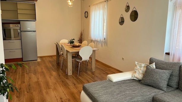 A compact living space with a kitchenette, dining area, and a sofa.