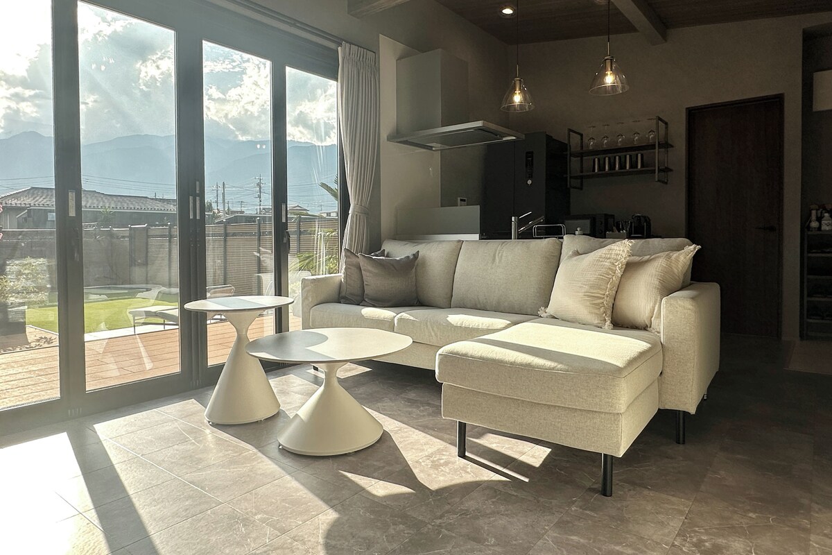 A modern living room with a sofa, coffee table, and pendant lights.