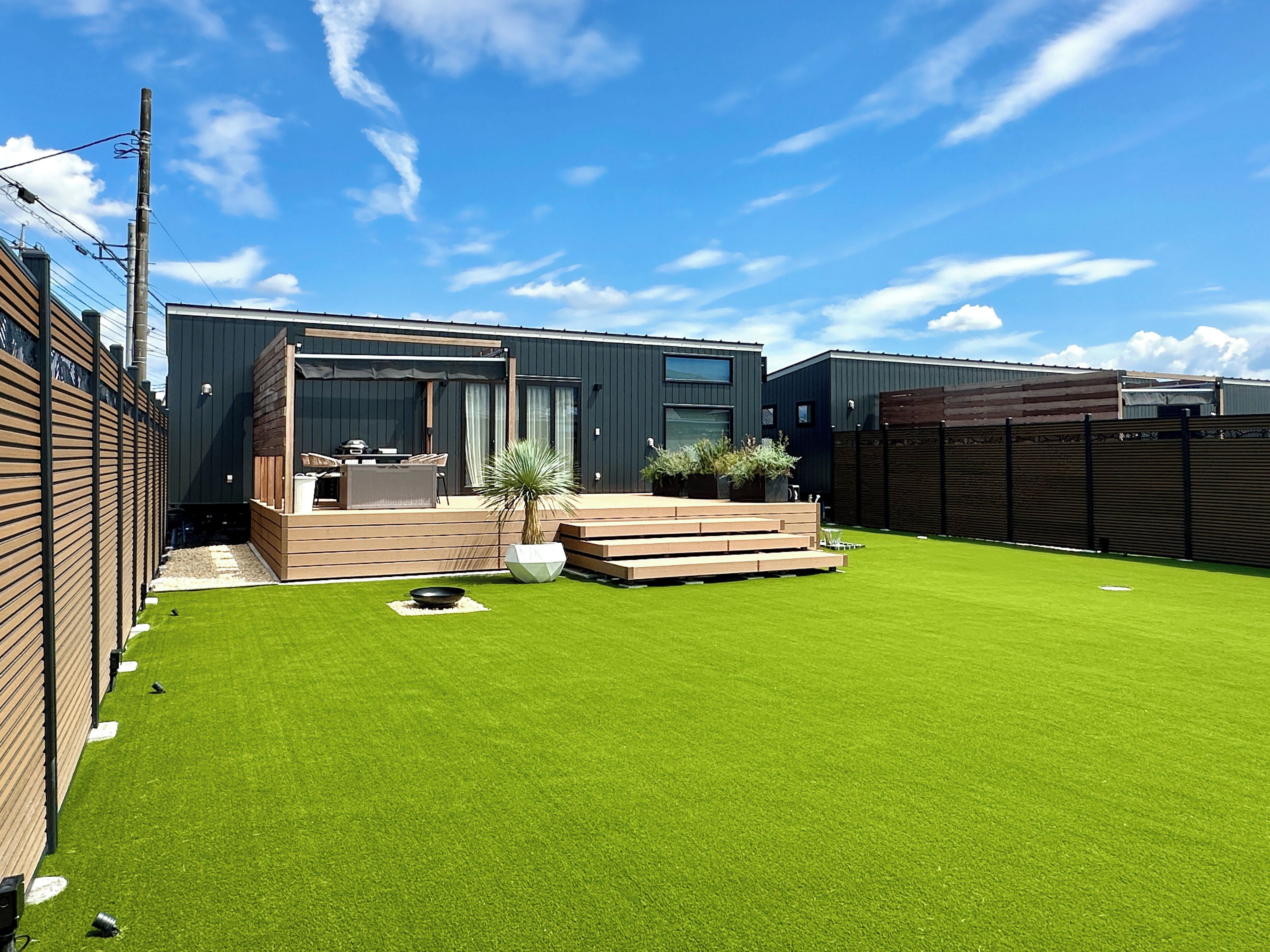 A modern house with a well-maintained lawn and a patio area.