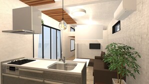 Une cuisine moderne dotée d’une cuisinière intégrée, d’un évier et d’un coin repas avec un canapé et une plante en pot.