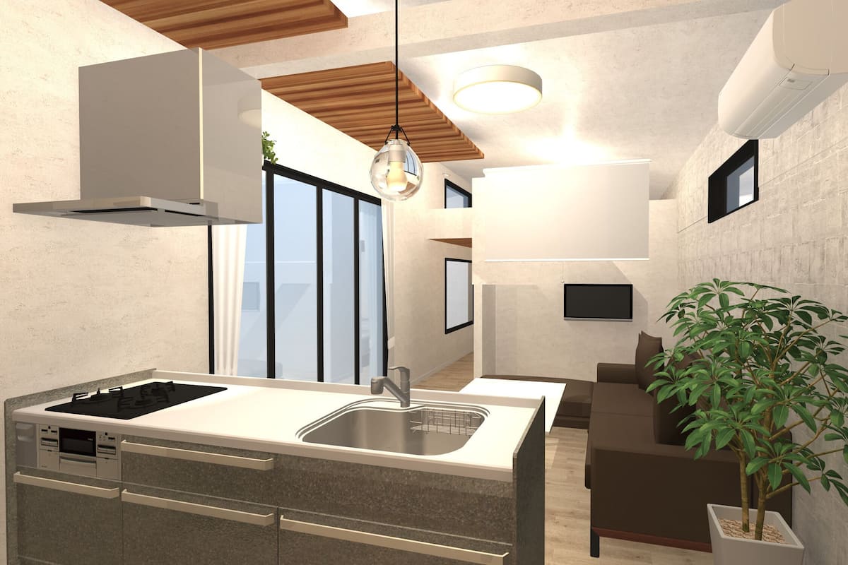 Una cocina moderna con estufa integrada, fregadero y zona de comedor con sofá y planta en maceta.